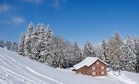 Fotoprint; Oostenrijks landschap met blokhut in de sneeuw 300(h)x500(b)cm